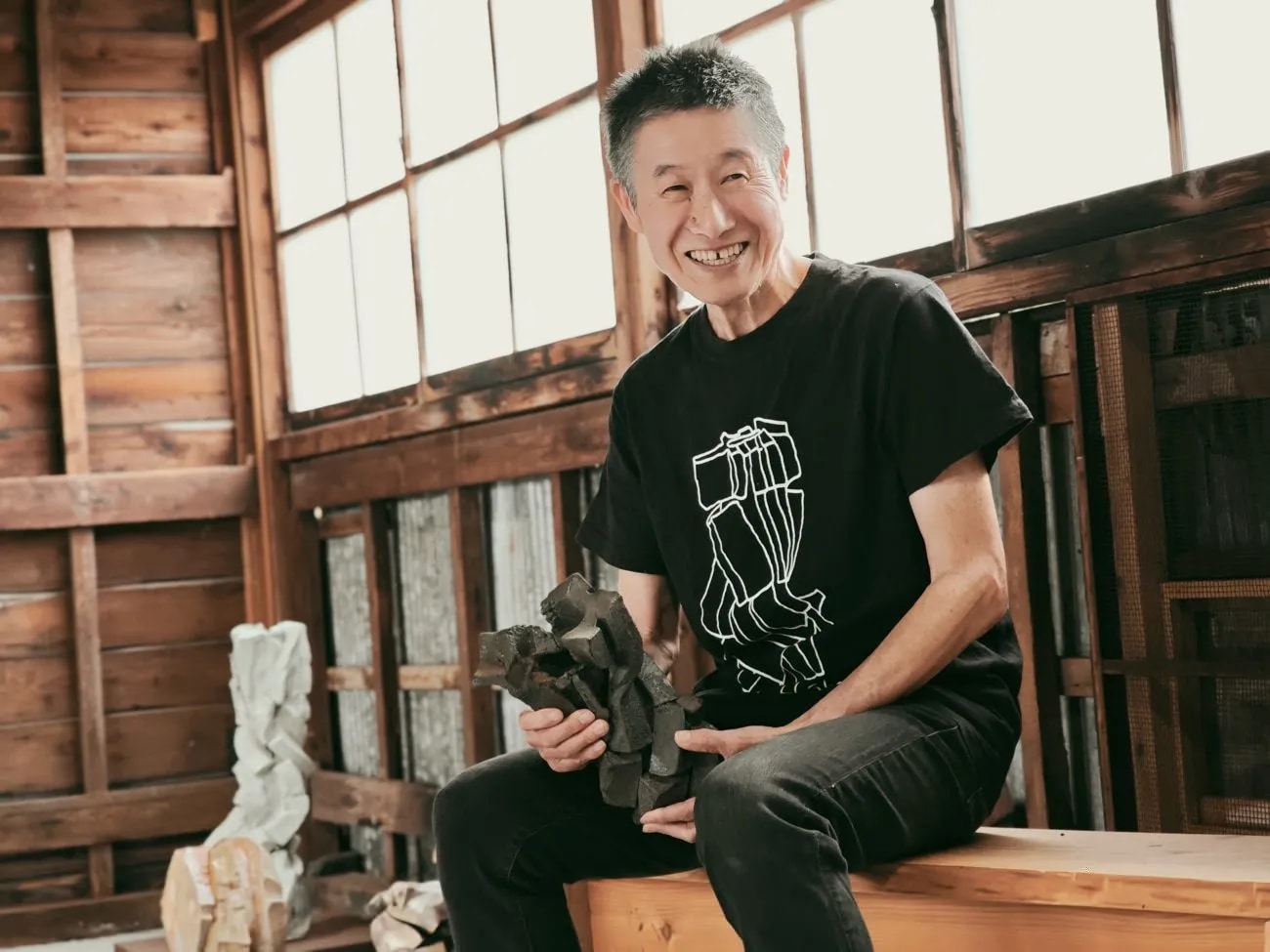 Shozo Michikawa seated in his wooden studio